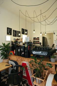 Cozy café interior in Helsinki featuring modern decor and lush plants.