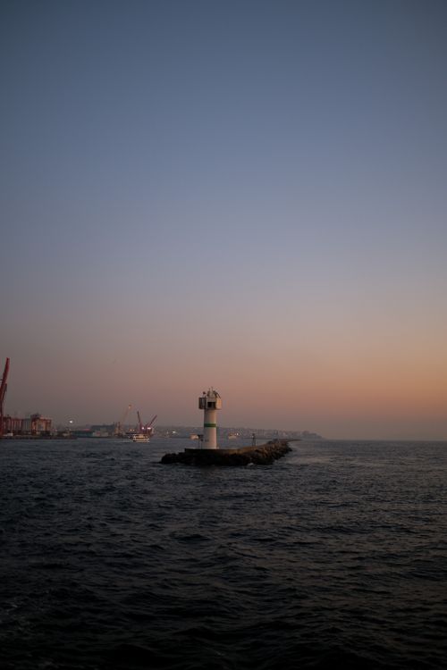 Free A serene view of a lighthouse on a breakwater during twilight on the Istanbul coastline. Stock Photo