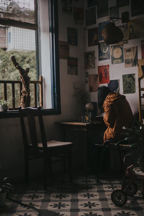 бесплатная Женщина, сидящая на стуле у окна Стоковое фото