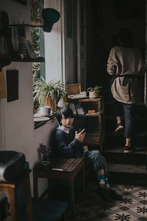 Girl Sitting While Holding Smartphone