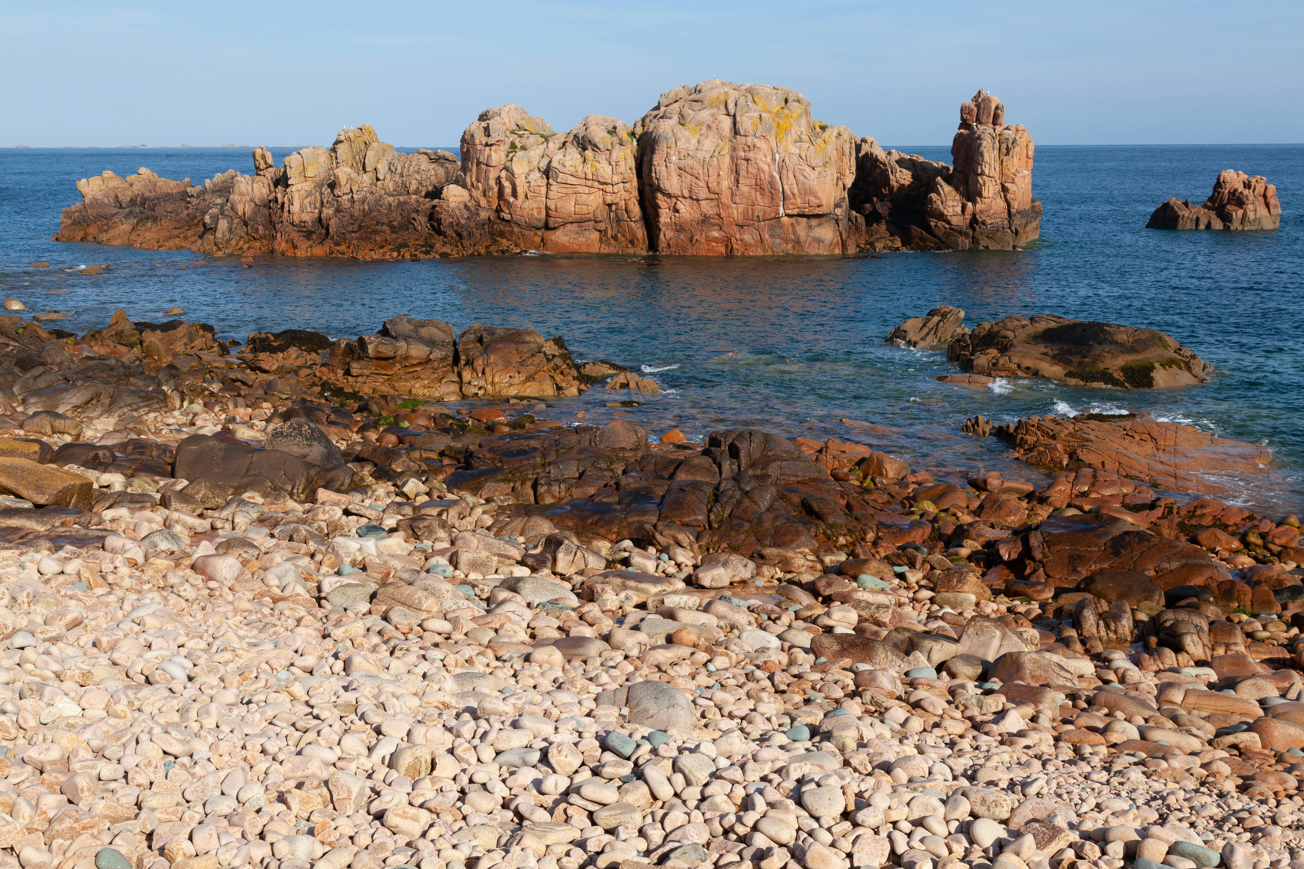 a rocky shore with rocks and a body of water