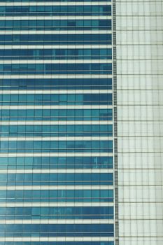 Close-up of a glass facade of a modern skyscraper in Bangkok, Thailand.