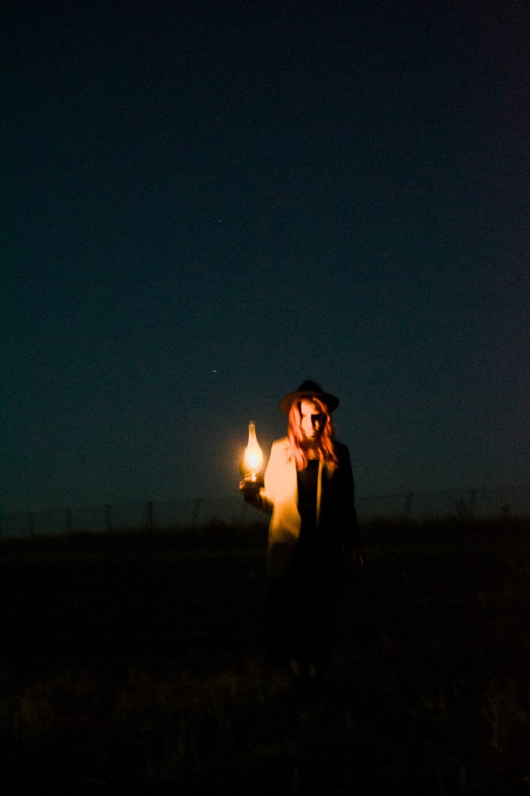 Woman With Kerosene Lamp In Field At Night