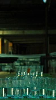 Artistic arrangement of translucent glasses in a dimly lit indoor setting, emphasizing mood.