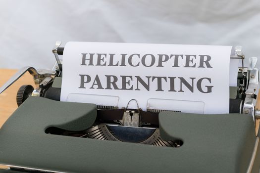 A typewriter with a paper that says helicopter parenting