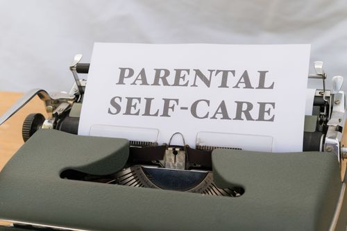 Free Close-up of a typewriter with the text 'Parental Self-Care.' Stock Photo