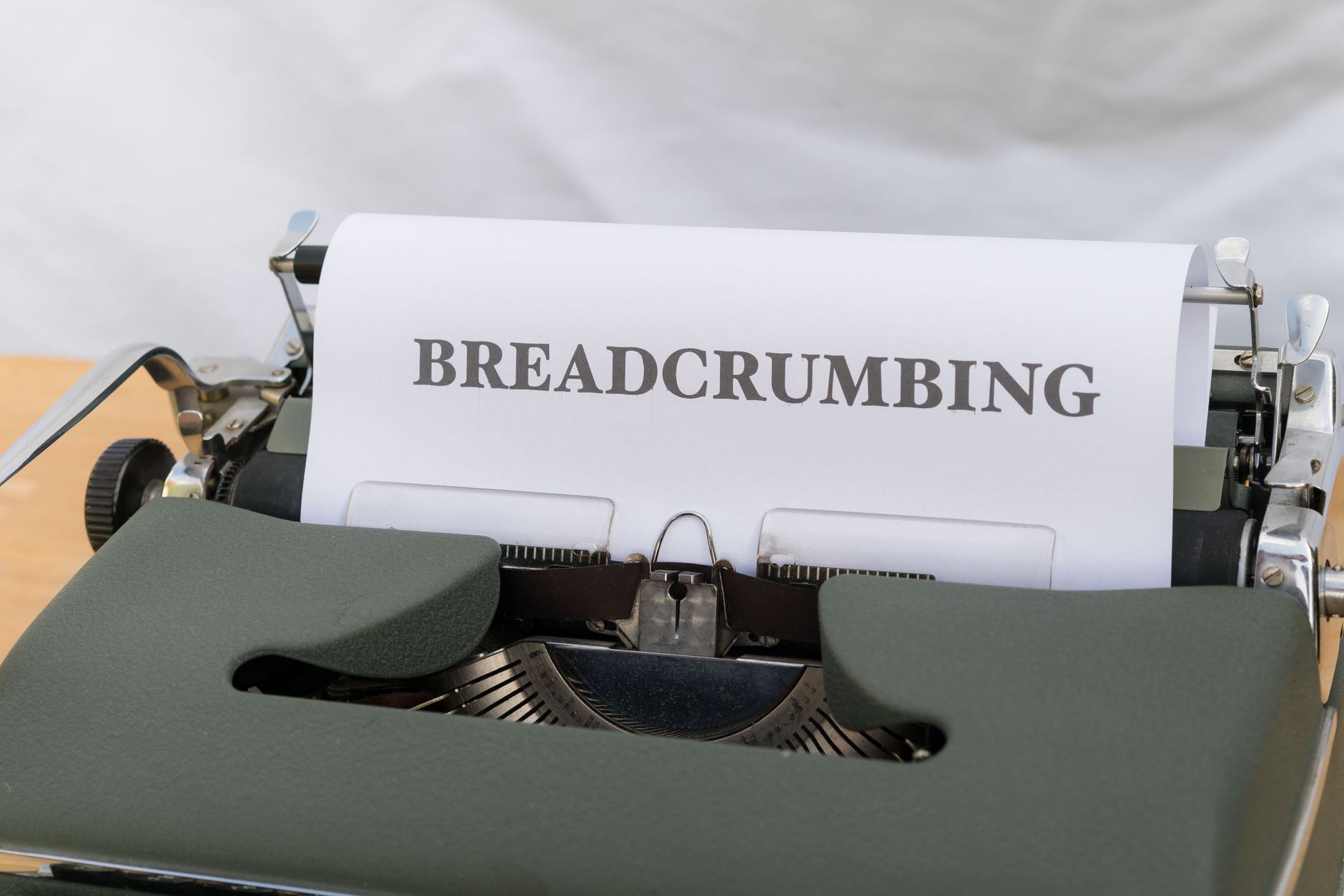 Close-up of a vintage typewriter with paper displaying the word 'BREADCRUMBING'.