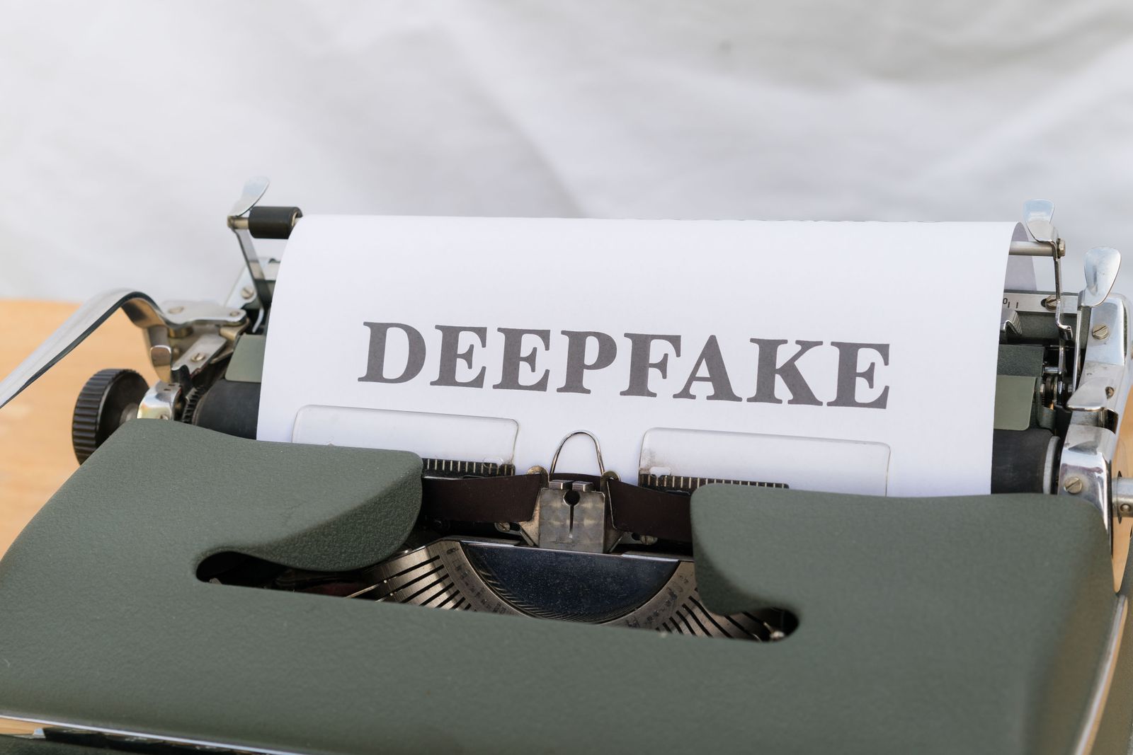 Old typewriter with paper labeled DEEPFAKE — symbol of AI-generated content