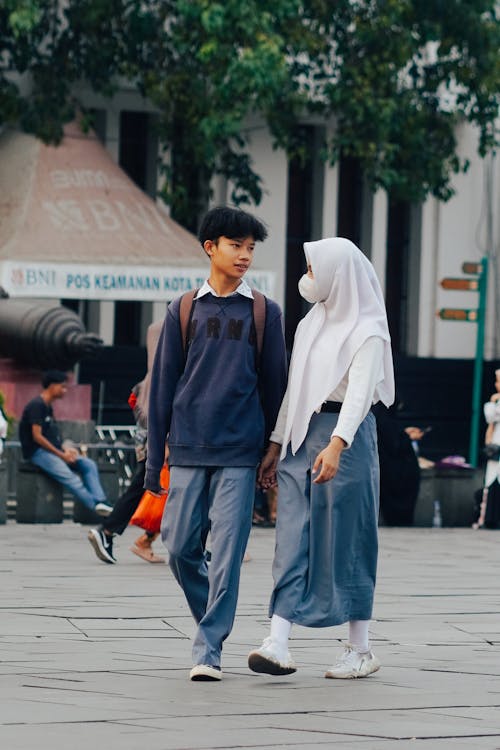 Boy and Girl in Hijab Walking Together in City 