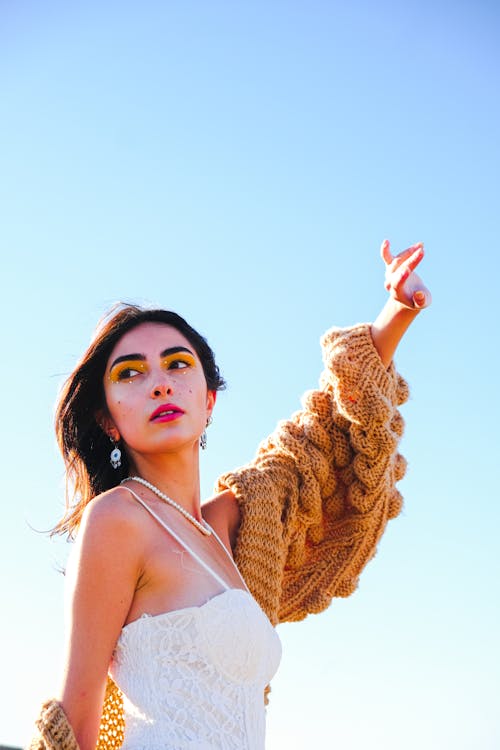 Woman in White Dress Posing with Arm Raised