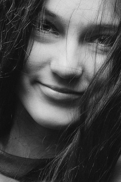 Free Close-up black and white portrait of a smiling teenage girl with long brunette hair. Stock Photo