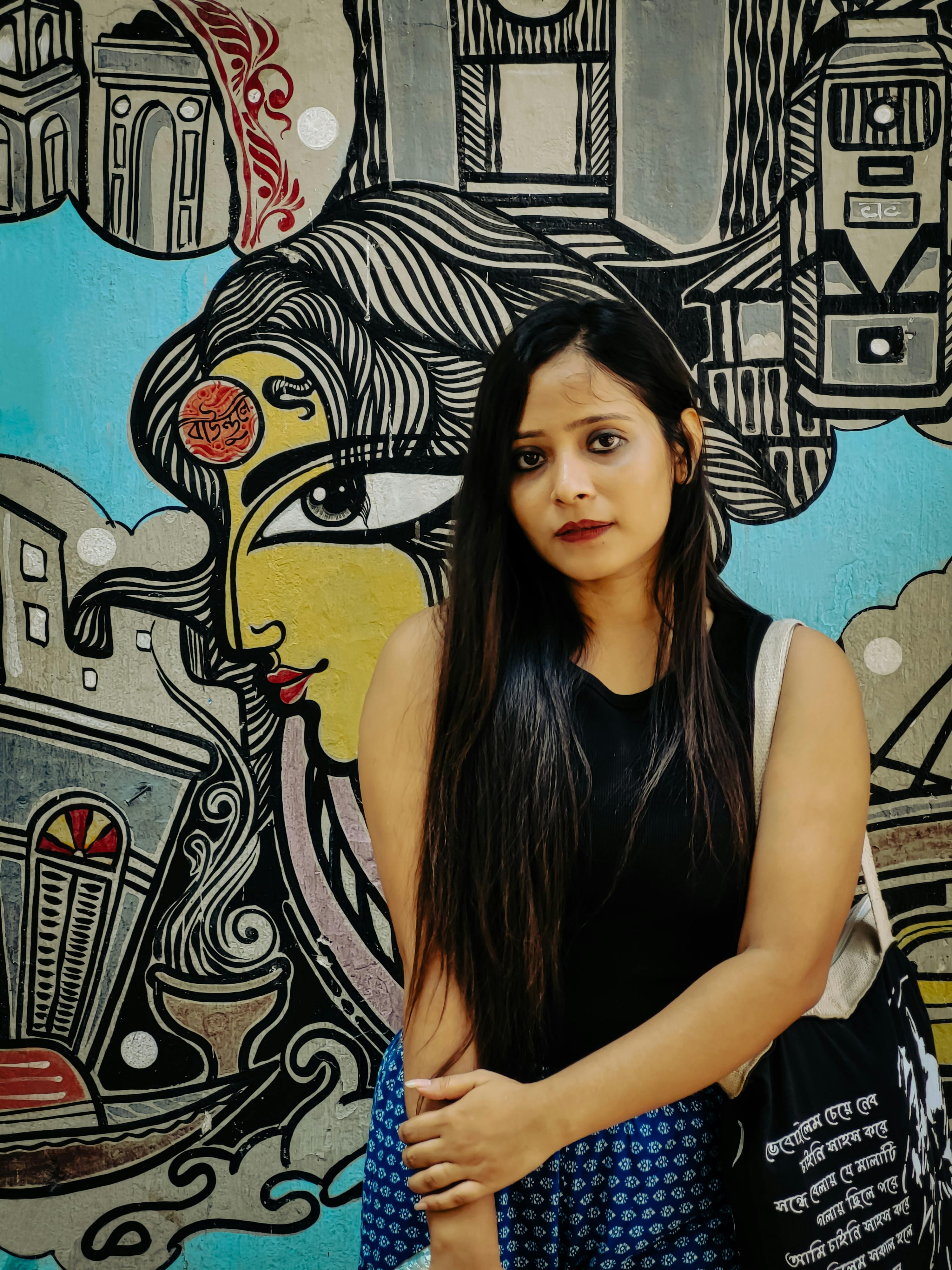 Woman posing in front of colorful street art mural in Kolkata, highlighting urban fashion and culture.