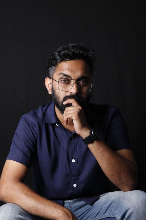 Free Studio portrait of a bearded man in glasses with a thoughtful expression against a black background. Stock Photo