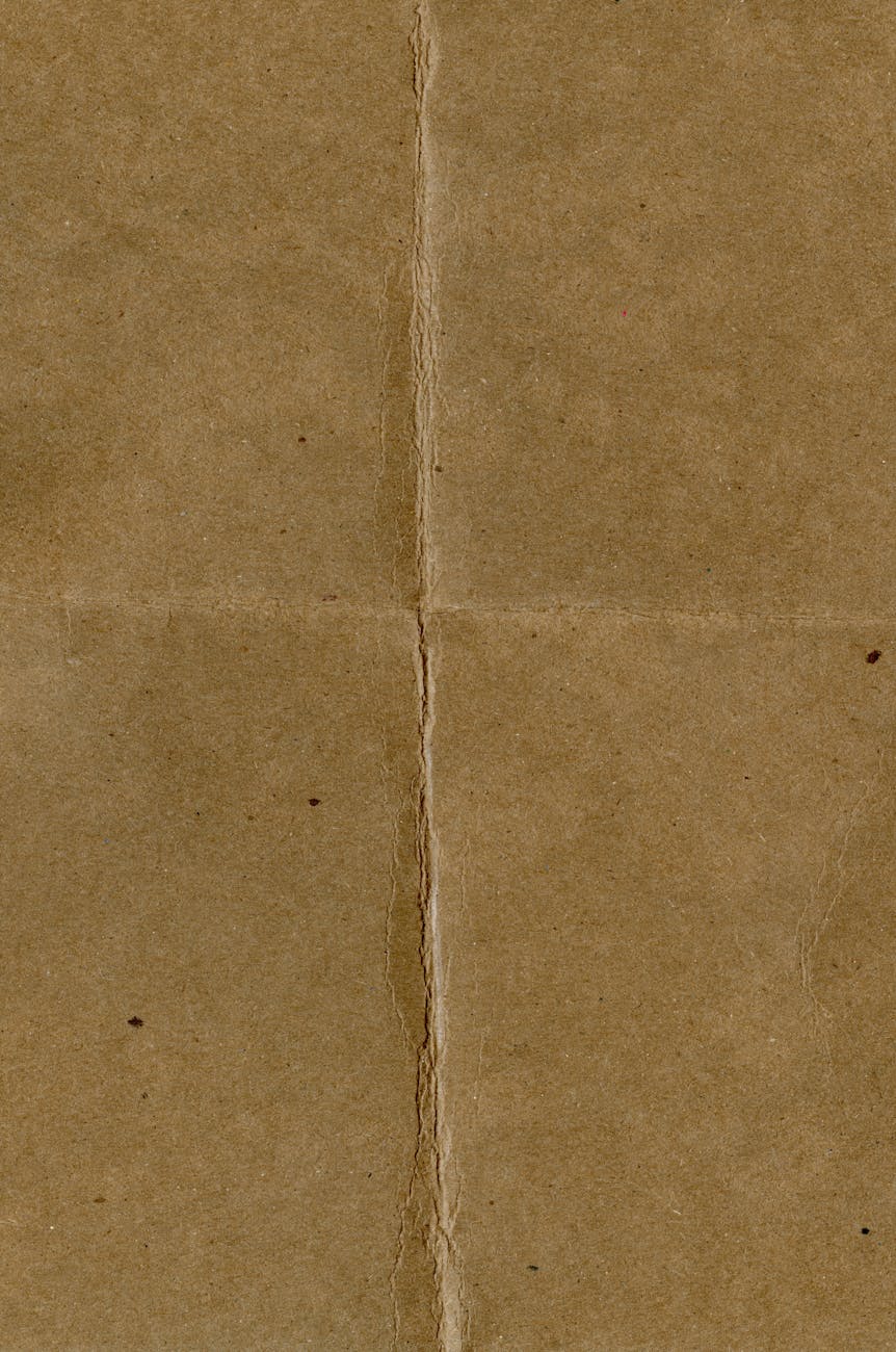 Close-up of an aged brown paper with central crease and subtle texture.
