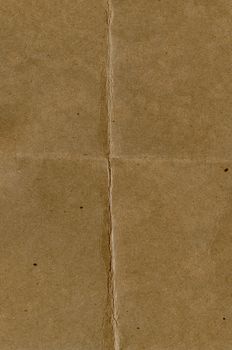 Close-up of an aged brown paper with central crease and subtle texture.. close, aged, brown