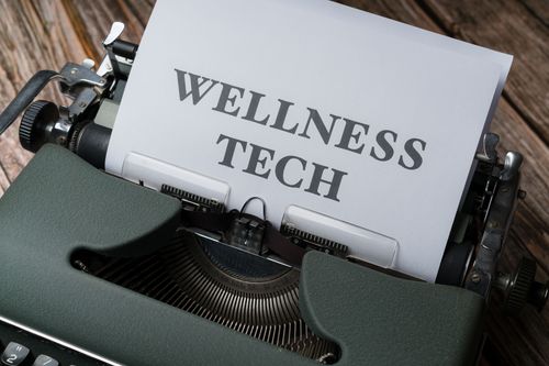 Free Close-up of a typewriter with paper displaying 'WELLNESS TECH'. Stock Photo