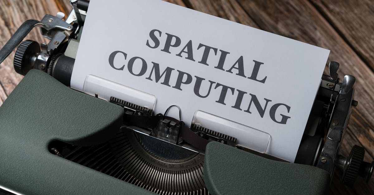 A vintage typewriter with a paper displaying the text 'SPATIAL COMPUTING' on a wooden desk.