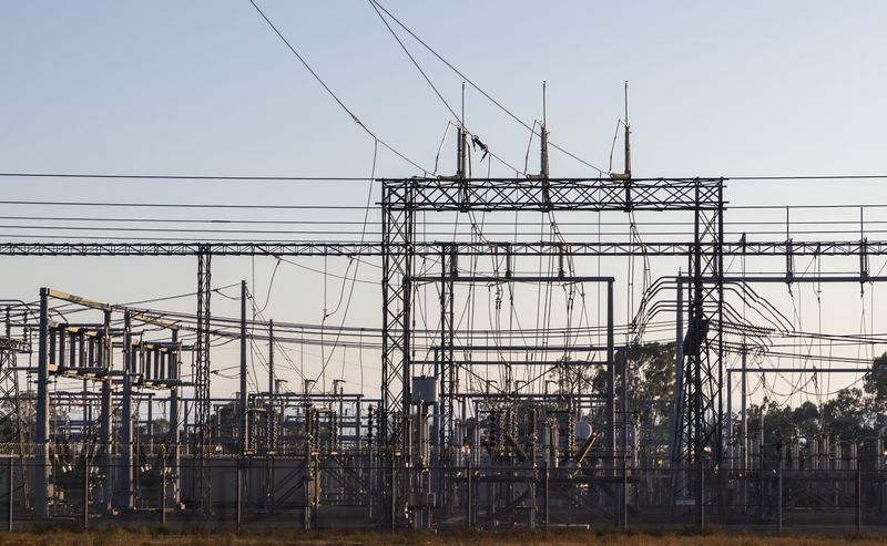 High-voltage switchgear and gantries at an electrical substation — photo by Robert So on Pexels