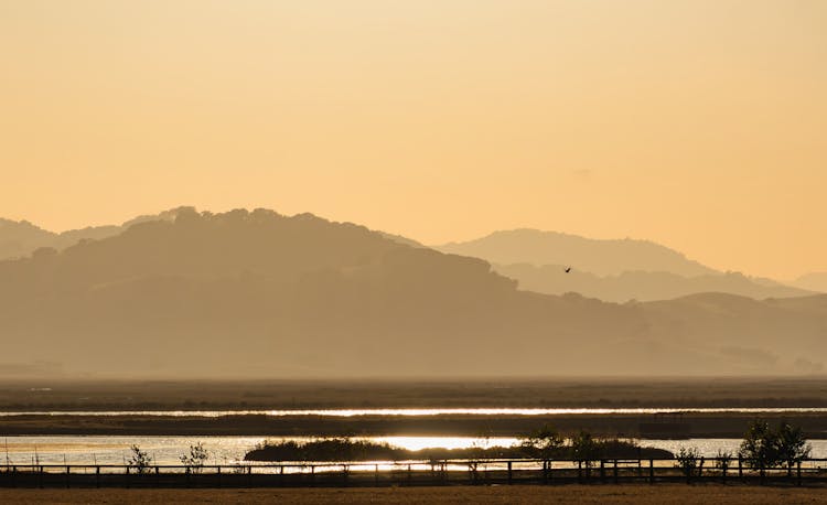 Hilly Landscape With A River At Sunrise