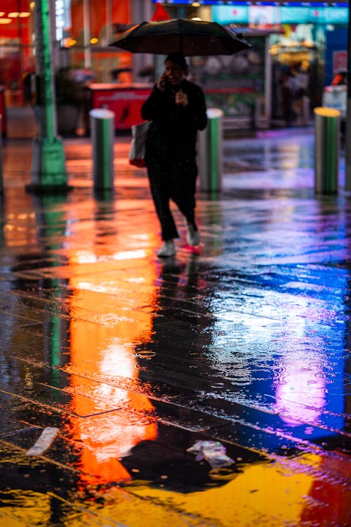 Woman with Umbrella Walking on a Night Street under Rain