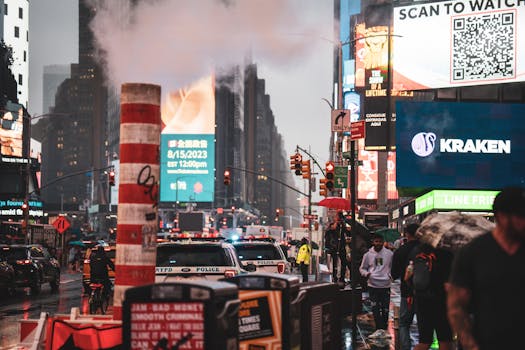 Bustling city life in Times Square with pedestrians, traffic, and illuminated billboards at dusk.