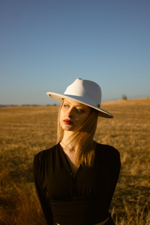 Model in a White Hat and Black Blouse in a Field