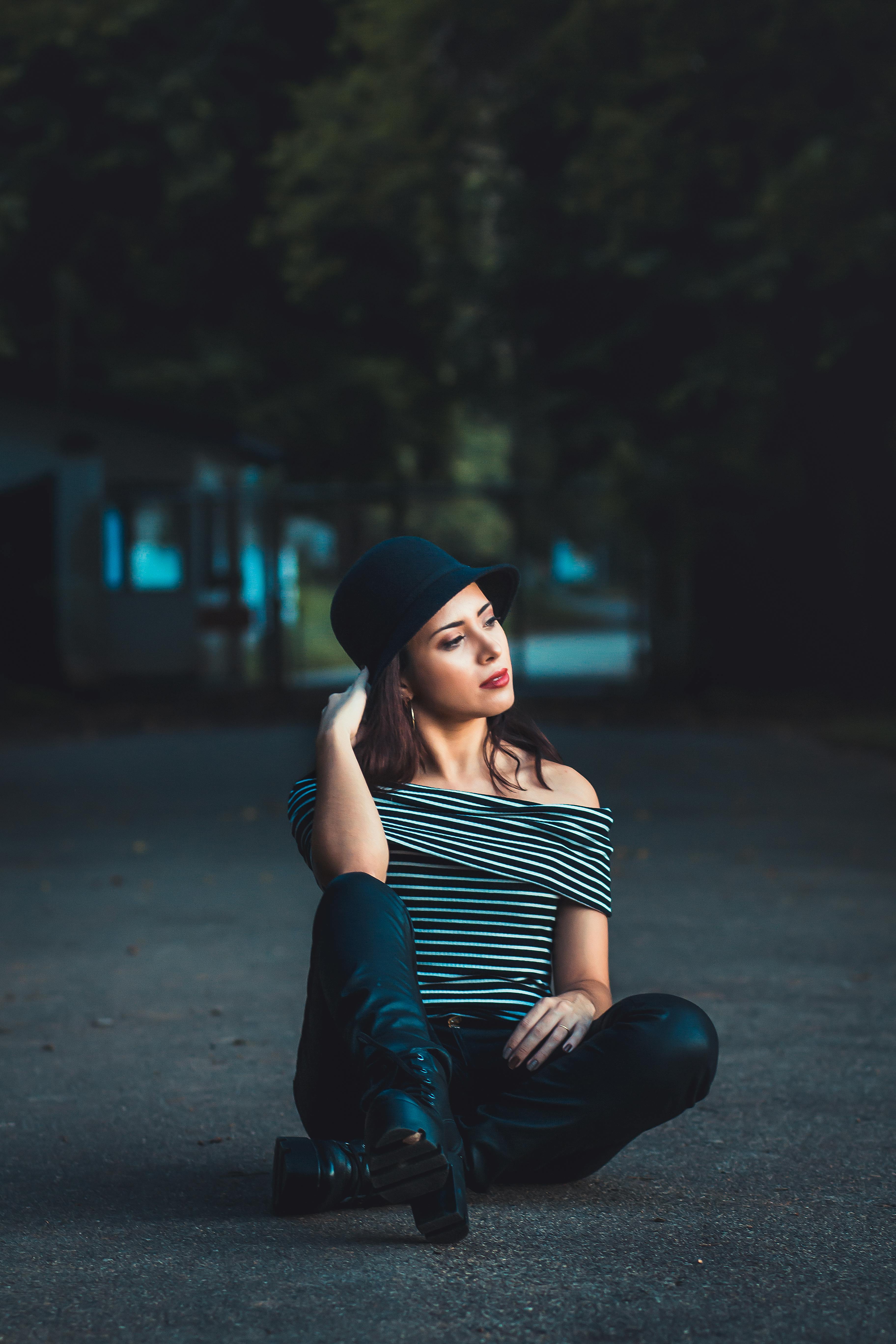 一位时尚女性头戴条纹帽子，在户外摆出姿势