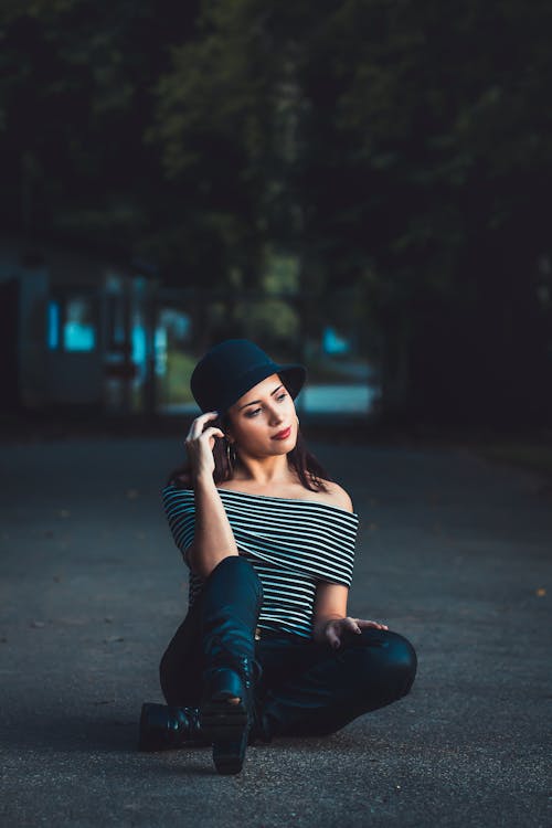 Woman Sitting on Cement Pavement