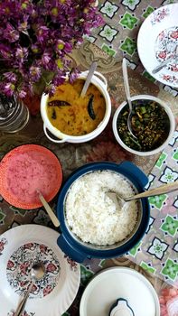 Authentic Indian meal setup with rice, lentil stew, and side dishes, top view.