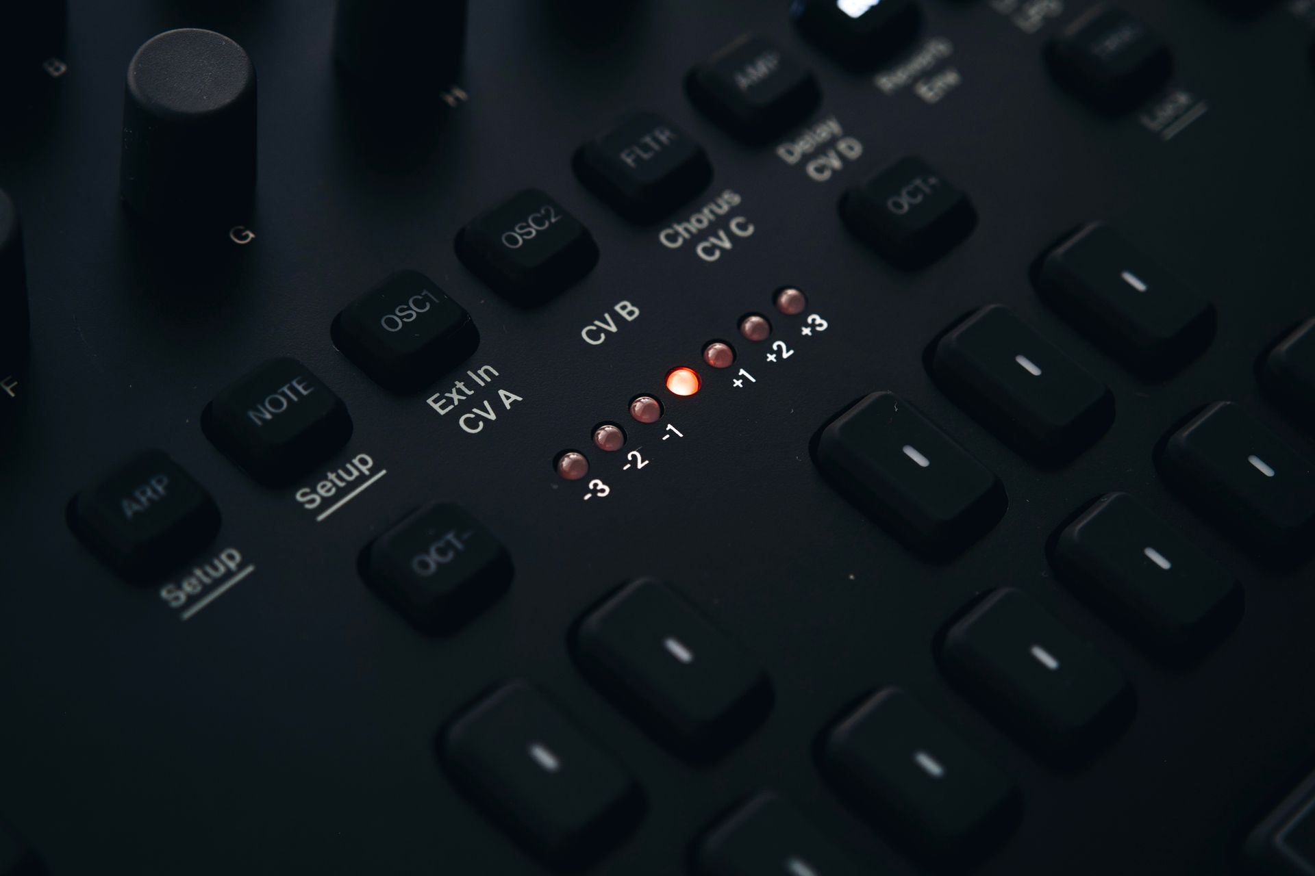 Detailed view of a dark electronic audio interface with knobs and buttons.