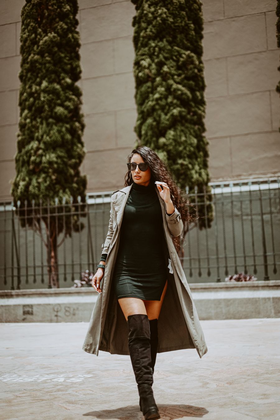 Woman in a long trench coat and knee-high boots
