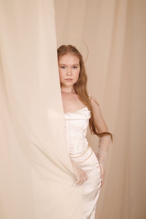 Portrait of Blonde Woman Among Curtains