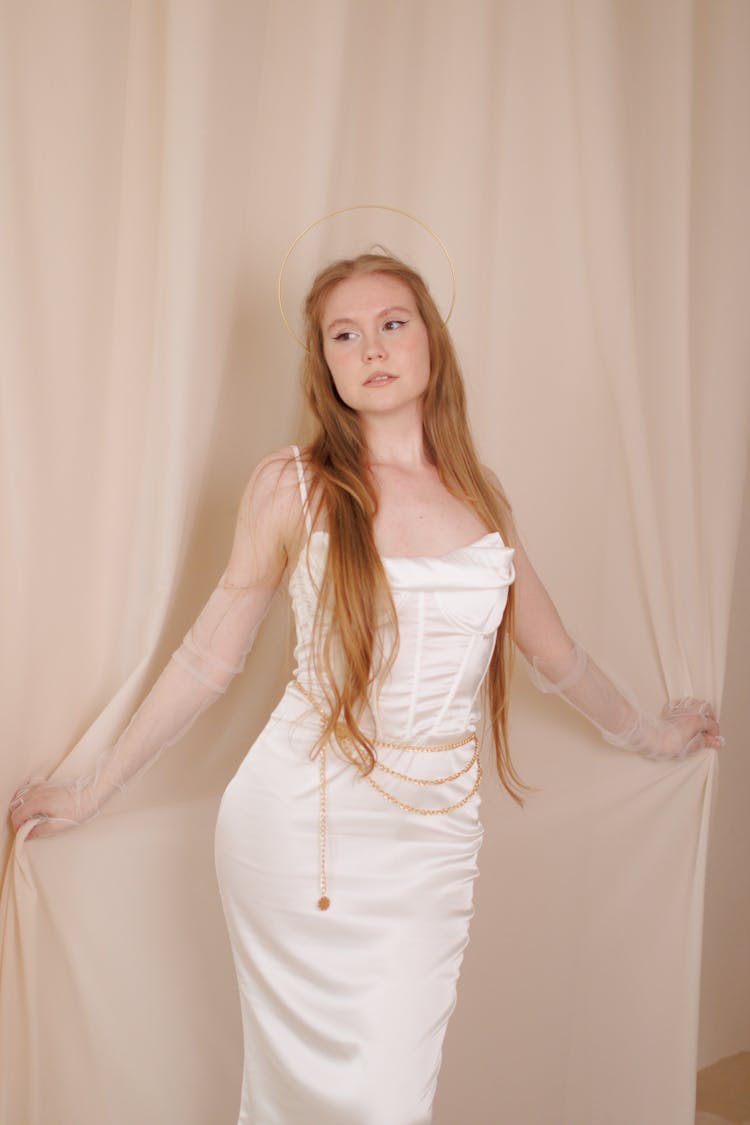 Portrait Of A Beautiful Redhead Wearing A White Dress And A Halo