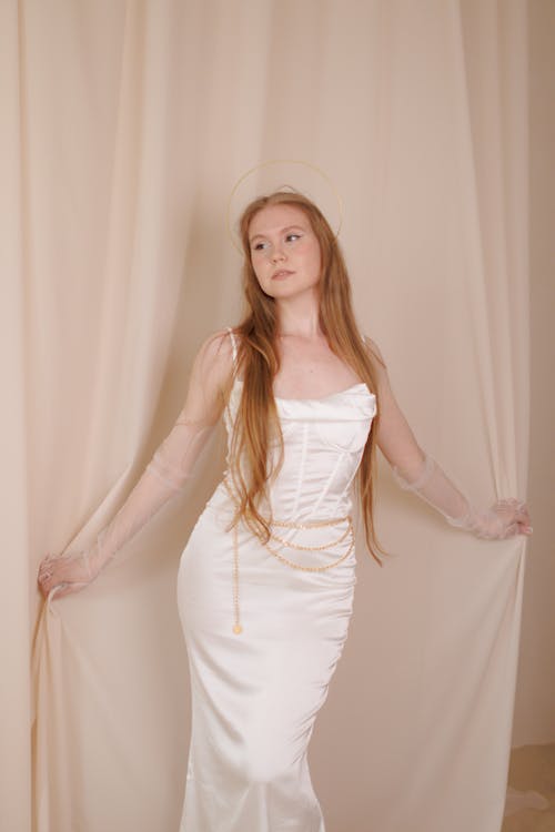 Person Posing in White Gown with Arms Spread