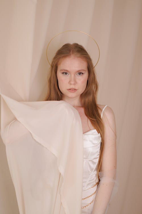 Person Posing in White Gown Behind a Curtain