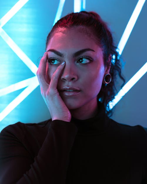 Portrait of a Pretty Brunette Standing in front of Blue Neons