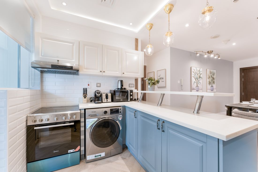 Contemporary modular kitchen with blue island and white cabinets