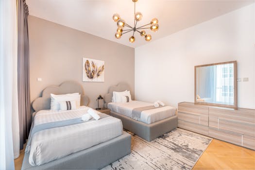 A stylish modern twin bedroom with elegant decor and warm lighting ambiance.