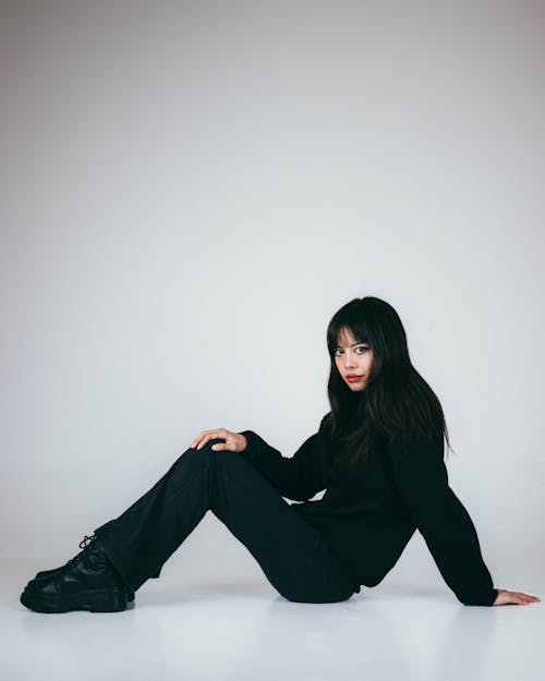 Young Woman in Black Clothing Sitting on the Floor 