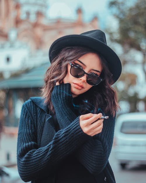 Woman in a Black Hat Smoking a Cigarette