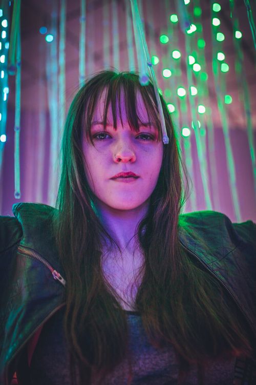 Free Portrait of a young woman with colorful neon lights. Vibrant and artistic photography. Stock Photo