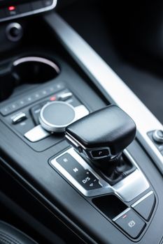 Close-up of a sleek gearshift in a modern car interior, highlighting luxury design.