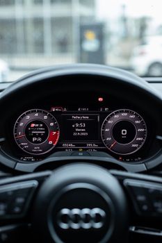 Close-up of an Audi steering wheel and dashboard featuring digital displays and controls.