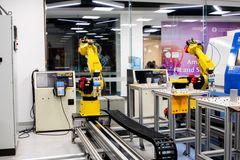 Robotic arms in action within a modern industrial control room setting, showcasing technology and production.