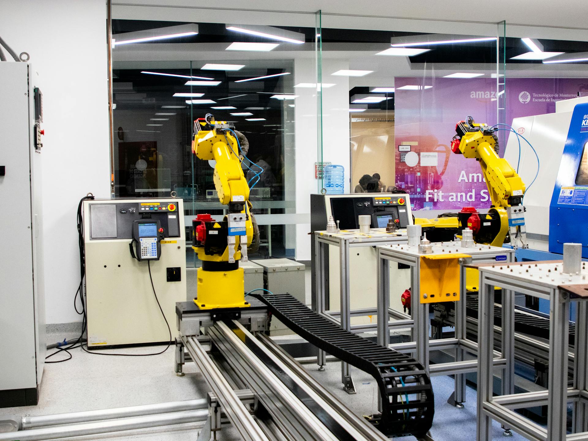 Robotic arms in action within a modern industrial control room setting, showcasing technology and production.