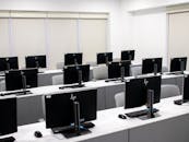 A classroom with rows of computers and monitors