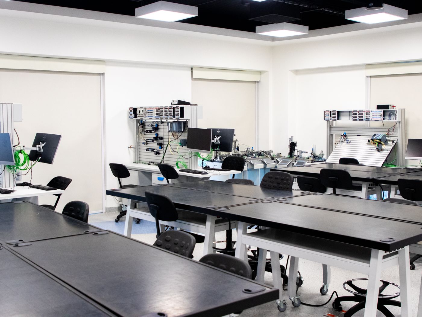Aula moderna equipada con computadoras y mobiliario tecnológico