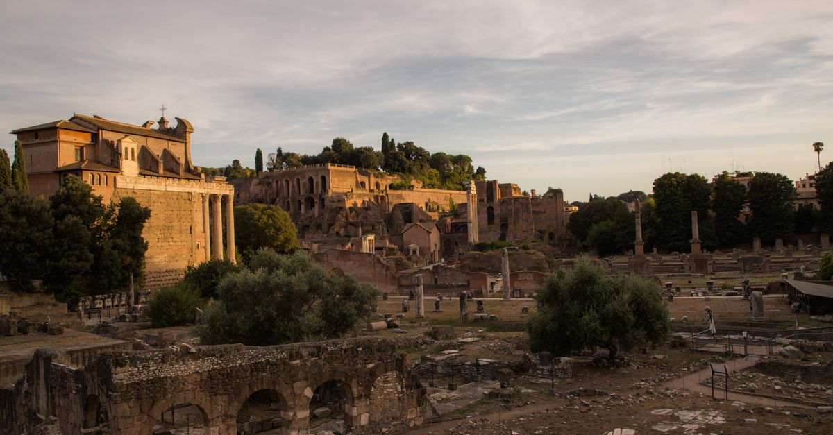 Atmospheric view of ancient Roman ruins at sunset, capturing the historic charm of Rome, Italy.