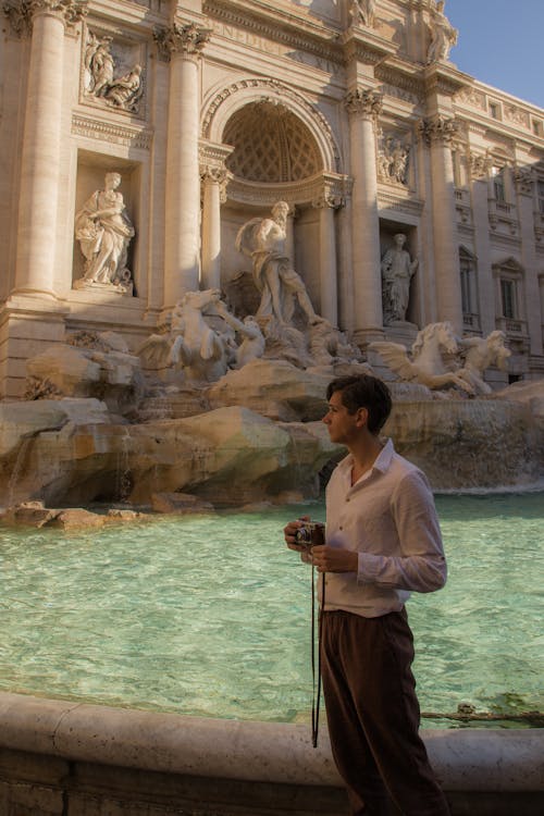 Tourist with Camera by Trevi Fountain in Rome