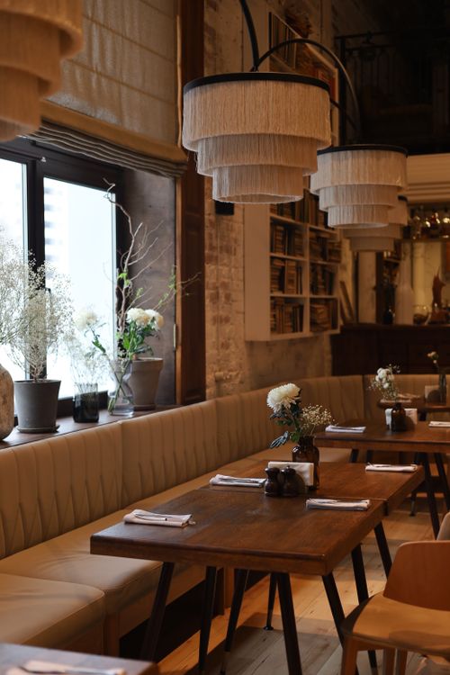Free Elegant restaurant interior with wooden tables and pendant lights. Stock Photo